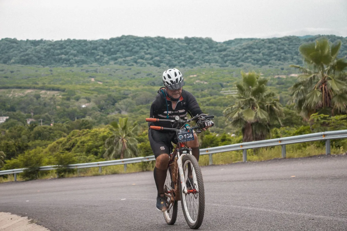 Cycliste en train de pédaler sur un parcours vallonné avec différents niveaux de difficulté.