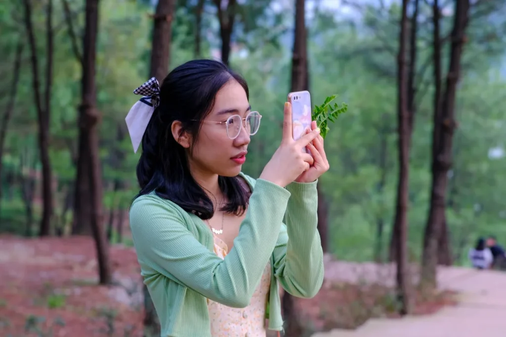 Personne regardant son téléphone avec des images retouchées et des produits cosmétiques autour