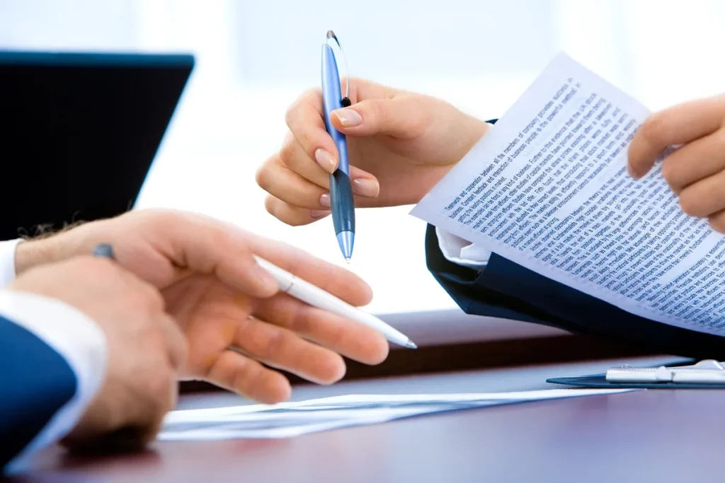 Mains examinant des documents de recherche et des graphiques de données sur un bureau