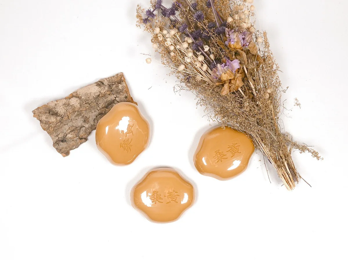 Savon naturel, pot de miel et beurre de karité sur un plan de salle de bain en plein jour