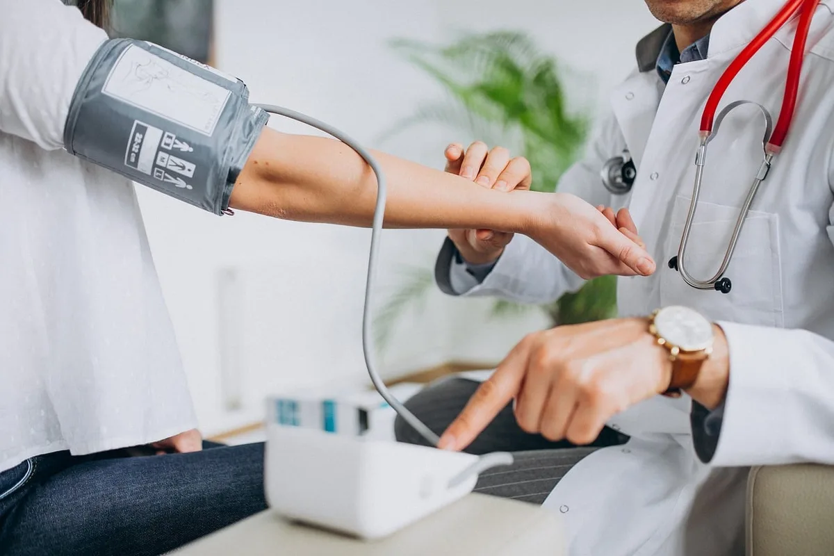 Consultation médicale avec un médecin et une boîte de gélules sur la table
