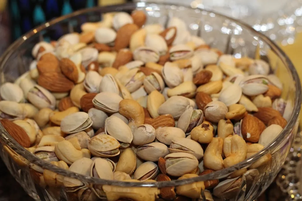 Bol d'oléagineux (amandes, pistaches, noix) sur une table de cuisine en plein jour